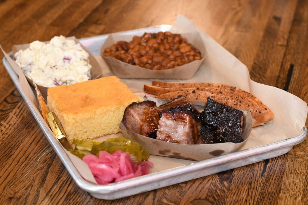 meal from porky butts bbq with cornbread, beans, bbq, and more